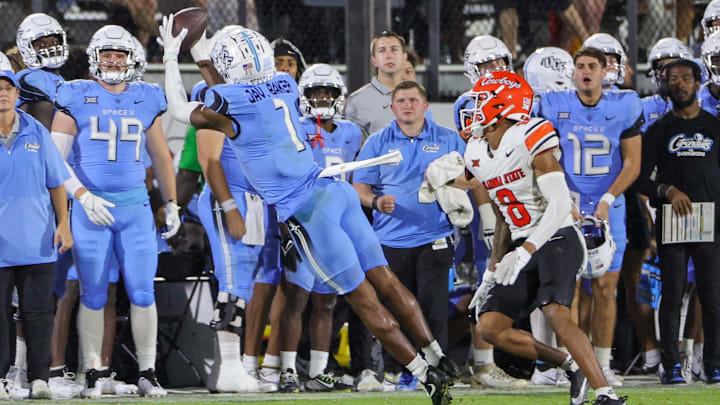 Nov 11, 2023; Orlando, Florida, USA; UCF Knights wide receiver Javon Baker (1) catches a pass in front of Oklahoma State Cowboys cornerback D.J. McKinney (8) during the second half at FBC Mortgage Stadium. Mandatory Credit: Mike Watters-USA TODAY Sports