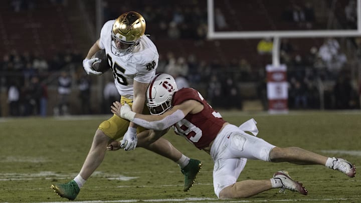 Nov 29, 2025; Stanford, California, USA;  Stanford Cardinal safety Charlie Eckhardt (39) attempts to tackle Notre Dame Fighting Irish tight end Jack Larsen (85) during the fourth quarter at Stanford Stadium. Mandatory Credit: Stan Szeto-Imagn Images