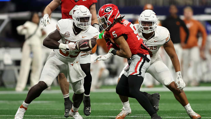 Dec 7, 2024; Atlanta, GA, USA; Texas Longhorns linebacker David Gbenda (33) causes a fumble on Georgia Bulldogs wide receiver Anthony Evans III (5) during the second half in the 2024 SEC Championship game at Mercedes-Benz Stadium. Mandatory Credit: Brett Davis-Imagn Images