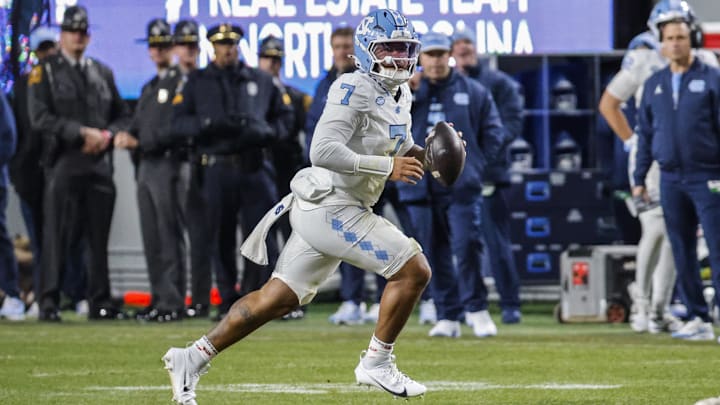 Nov 29, 2025; Raleigh, North Carolina, USA;  North Carolina Tar Heels quarterback Gio Lopez (7) runs with the football during the first half of the game against NC State Wolfpack at Carter-Finley Stadium.  Mandatory Credit: Jaylynn Nash-Imagn Images