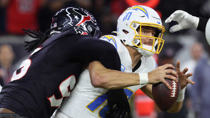 Jan 11, 2025; Houston, Texas, USA; Los Angeles Chargers quarterback Justin Herbert (10) is sacked by Houston Texans defensive end Denico Autry (96) during the third quarter in an AFC wild card game at NRG Stadium. 