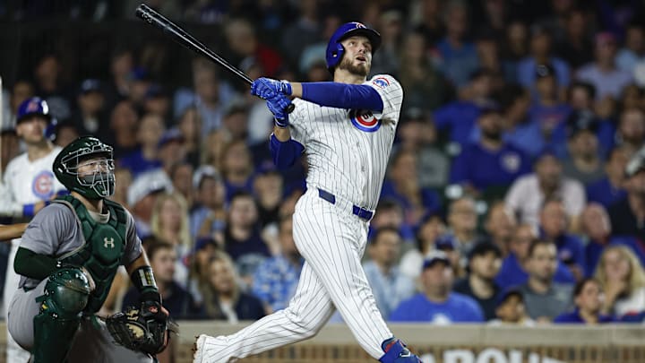 Sep 17, 2024; Chicago, Illinois, USA; Chicago Cubs first baseman Michael Busch (29) hits an RBI-single against the Oakland Athletics during the third inning at Wrigley Field. 