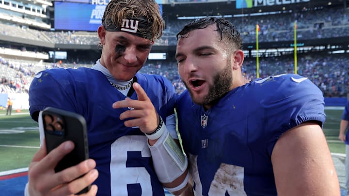 Sep 28, 2025; East Rutherford, New Jersey, USA; New York Giants quarterback Jaxson Dart (6) and running back Cam Skattebo (44) record a video on a smartphone after defeating the Los Angeles Chargers at MetLife Stadium.