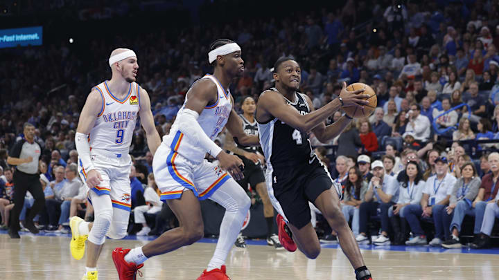 Dec 25, 2025; Oklahoma City, Oklahoma, USA; San Antonio Spurs guard De'Aaron Fox (4) drives to the basket beside Oklahoma City Thunder guard Shai Gilgeous-Alexander (2) during the second quarter at Paycom Center. Mandatory Credit: Alonzo Adams-Imagn Images