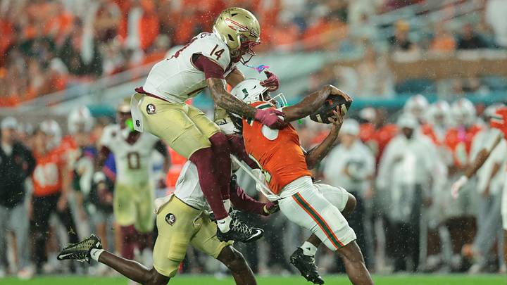 Oct 17, 2026; Miami Gardens, Florida, USA; Miami Hurricanes wide receiver Malachi Toney (1) makes a catch against Florida State Seminoles defensive back Ja'Bril Rawls (6) and defensive back Ma'Khi Jones (14) during the first quarter at Hard Rock Stadium. Mandatory Credit: Sam Navarro-Imagn Images Oct 17, 2026; Miami Gardens, Florida, USA; Miami Hurricanes wide receiver Malachi Toney (1) makes a catch against Florida State Seminoles defensive back Ja'Bril Rawls (6) and defensive back Ma'Khi Jones (14) during the first quarter at Hard Rock Stadium. Mandatory Credit: Sam Navarro-Imagn Images