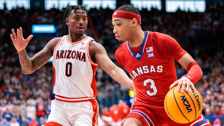 Mar 8, 2025; Lawrence, Kansas, USA; Kansas Jayhawks guard Dajuan Harris Jr. (3) drives to the basket around Arizona Wildcats guard Jaden Bradley (0) during the second half at Allen Fieldhouse. Mandatory Credit: William Purnell-Imagn Images