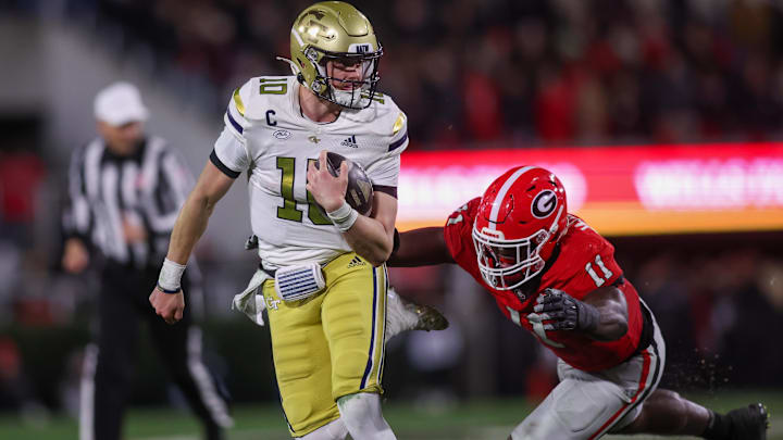 Nov 29, 2024; Athens, Georgia, USA; Georgia Tech Yellow Jackets quarterback Haynes King (10) runs the ball past Georgia Bulldogs linebacker Jalon Walker (11) in the second quarter at Sanford Stadium. Mandatory Credit: Brett Davis-Imagn Images