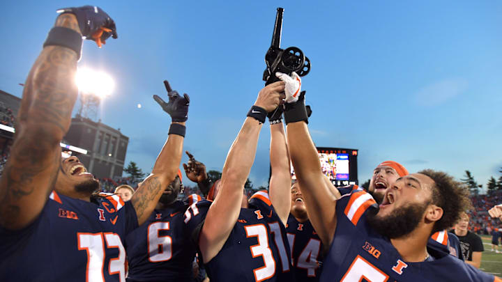 Oct 12, 2024; Champaign, Illinois, USA;  Fighting Illinois players celebrate with the Purdue Cannon in a 50-49 win against the Purdue Boilermakers at Memorial Stadium. Mandatory Credit: Ron Johnson-Imagn Images