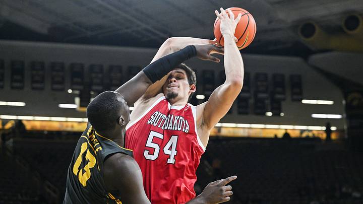 Nov 12, 2024; Iowa City, Iowa, USA; South Dakota Coyotes center Cameron Fens (54) is defended by Iowa Hawkeyes forward Ladji Dembele (13) during the first half at Carver-Hawkeye Arena. Mandatory Credit: Jeffrey Becker-Imagn Images