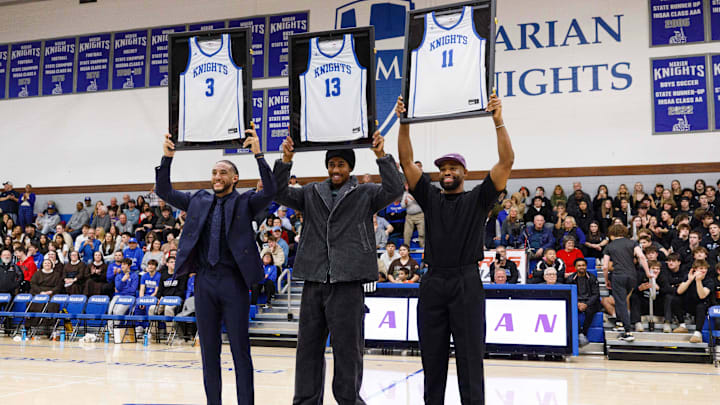 Former Marian basketball players Devin Cannady (3), Jaden Ivey (13) and Demetrius Jackson (11) hold up their jerseys.