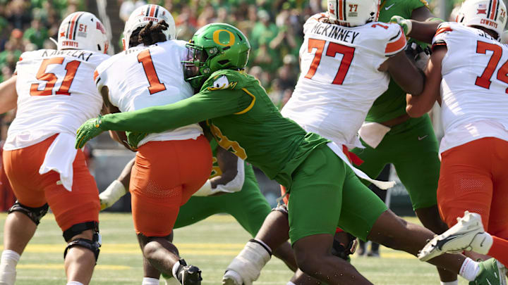 Sep 6, 2025; Eugene, Oregon, USA; Oregon Ducks linebacker Blake Purchase (9) tackles Oklahoma State Cowboys running back Kalib Hicks (1) during the second half at Autzen Stadium. Mandatory Credit: Troy Wayrynen-Imagn Images