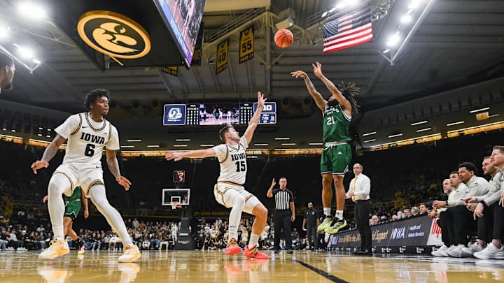 Chicago State Cougars guard Braelon Bush (21) shoots over Iowa Hawkeyes guard Brendan Hausen (15) and guard Tavion Banks (6)