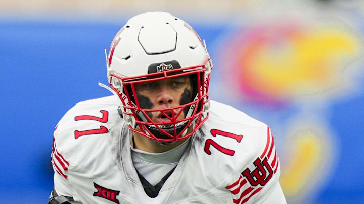 Nov 28, 2025; Lawrence, Kansas, USA; Utah Utes offensive lineman Caleb Lomu (71) gets ready before the snap during the second half against the Kansas Jayhawks at David Booth Kansas Memorial Stadium. Mandatory Credit: Jay Biggerstaff-Imagn Images