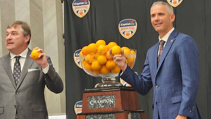 FSU head coach Mike Norvell and Georgia head coach Kirby Smart pose with oranges.