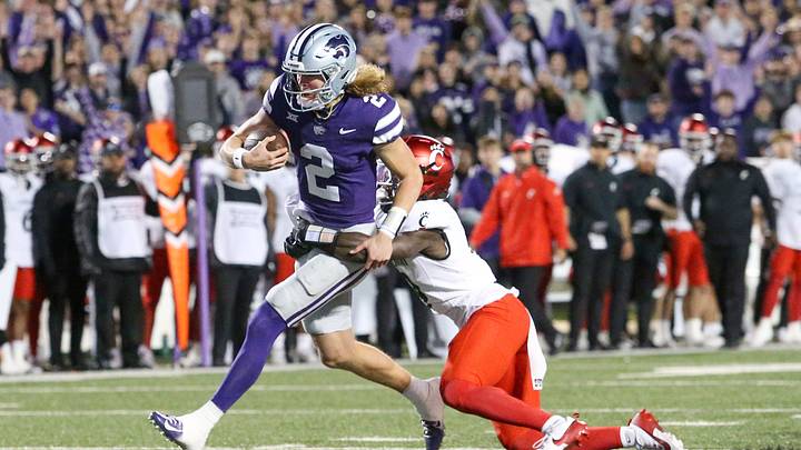Nov 23, 2024; Manhattan, Kansas, USA; Cincinnati Bearcats linebacker Jiquan Sanks (9) tries to tackle Kansas State Wildcats quarterback Avery Johnson (2) during the first quarter at Bill Snyder Family Football Stadium. Johnson scored a touchdown on the play. Mandatory Credit: Scott Sewell-Imagn Images