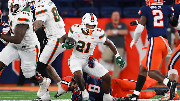 Nov 30, 2024; Syracuse, New York, USA; Syracuse Orange defensive back Justin Barron (8) tackles Miami Hurricanes running back Jordan Lyle (21) during the first half at the JMA Wireless Dome. Mandatory Credit: Rich Barnes-Imagn Images