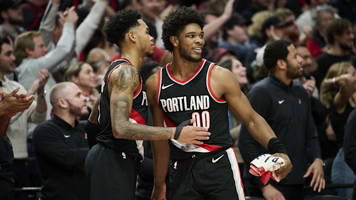 Jan 31, 2024; Portland, Oregon, USA; Portland Trail Blazers guard Scoot Henderson (00) celebrates with guard Anfernee Simons (1) during the second half against the Milwaukee Bucks at Moda Center. Mandatory Credit: Troy Wayrynen-Imagn Images