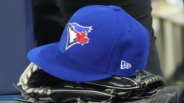 Apr 27, 2024; Toronto, Ontario, CAN; A Toronto Blue Jays hat and glove in the dugout during the third inning against the Los Angeles Dodgers at Rogers Centre. Mandatory Credit: John E. Sokolowski-Imagn Images