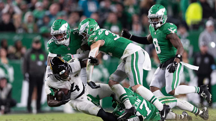 Nov 3, 2024; Philadelphia, Pennsylvania, USA; Jacksonville Jaguars running back Tank Bigsby (4) is tackled by Philadelphia Eagles linebacker Nakobe Dean (17) and cornerback Isaiah Rodgers (34) during the fourth quarter at Lincoln Financial Field. Mandatory Credit: Bill Streicher-Imagn Images
