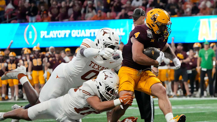 Arizona State running back Cam Skattebo (4) runs past Texas linebacker Anthony Hill Jr. (0) and Texas linebacker Liona Lefau (18) during the third quarter of the Chick-fil-A Peach Bowl in Atlanta on Wednesday, Jan. 1, 2025.