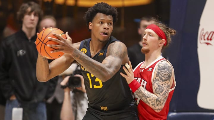 Feb 8, 2025; Morgantown, West Virginia, USA; West Virginia Mountaineers forward Amani Hansberry (13) backs down against Utah Utes guard Gabe Madsen (55) during the second half at WVU Coliseum. Mandatory Credit: Ben Queen-Imagn Images