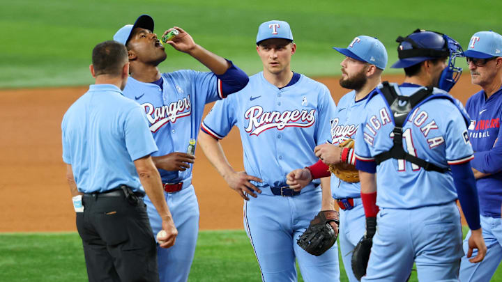 Jun 15, 2025; Arlington, Texas, USA;  Texas Rangers starting pitcher Kumar Rocker (80) is given a hydration drink during the fifth inning against the Chicago White Sox at Globe Life Field. 
