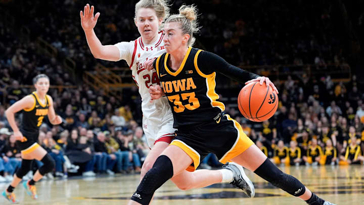 Iowa guard Lucy Olsen (33) drives to the lane as Wisconsin guard Natalie Leuzinger (24) defends during a Big Ten conference game Sunday, March 2, 2025 at Carver-Hawkeye Arena in Iowa City, Iowa.