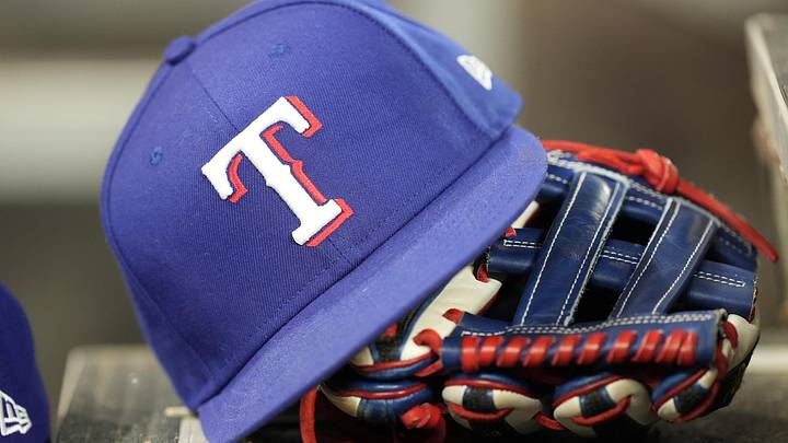 A hat and glove of a Texas Rangers player. A hat and glove of a Texas Rangers player.