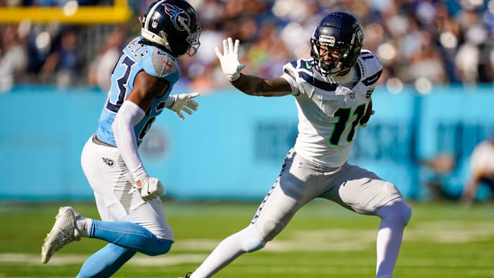 Seattle Seahawks wide receiver Jaxon Smith-Njigba (11) throws the stiff arm to Tennessee Titans safety Kevin Winston Jr. (23) during the second quarter at Nissan Stadium in Nashville, Tenn., Sunday, Nov. 23, 2025.