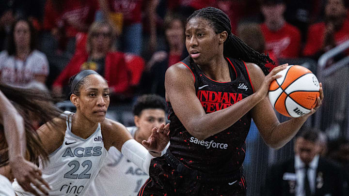 Sep 28, 2025; Indianapolis, Indiana, USA; Indiana Fever forward Aliyah Boston (7) holds the ball while Las Vegas Aces center A'ja Wilson (22) defends in the second half  during game four of the second round for the 2025 WNBA Playoffs at Gainbridge Fieldhouse. Mandatory Credit: Trevor Ruszkowski-Imagn Images