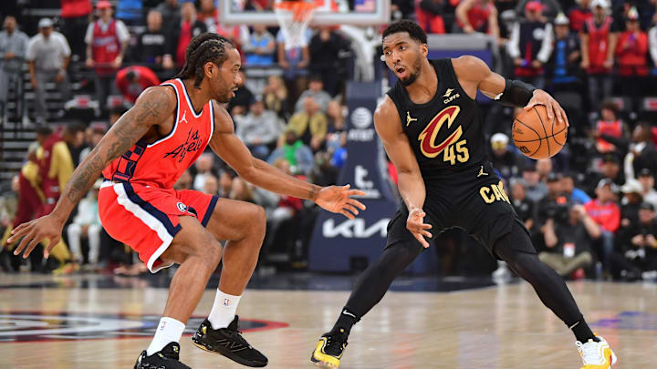 Mar 18, 2025; Inglewood, California, USA;  Cleveland Cavaliers guard Donovan Mitchell (45) controls the ball against Los Angeles Clippers forward Kawhi Leonard (2) during the first half at Intuit Dome. Mandatory Credit: Gary A. Vasquez-Imagn Images