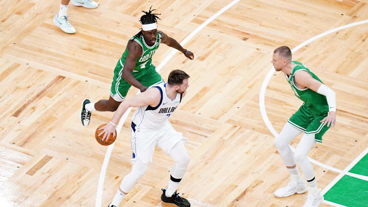 Jun 17, 2024; Boston, Massachusetts, USA; Dallas Mavericks guard Luka Doncic (77) controls the ball against Boston Celtics guard Jrue Holiday (4) and center Kristaps Porzingis (8) in the first quarter during game five of the 2024 NBA Finals at TD Garden. Mandatory Credit: David Butler II-Imagn Images Jun 17, 2024; Boston, Massachusetts, USA; Dallas Mavericks guard Luka Doncic (77) controls the ball against Boston Celtics guard Jrue Holiday (4) and center Kristaps Porzingis (8) in the first quarter during game five of the 2024 NBA Finals at TD Garden. Mandatory Credit: David Butler II-Imagn Images