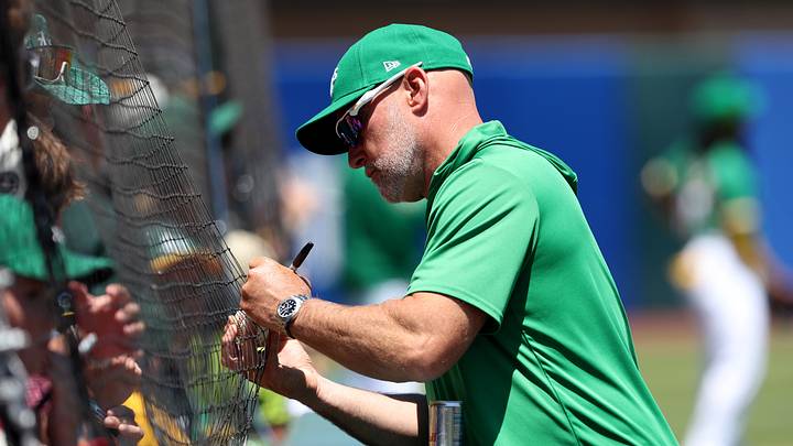 Jul 5, 2026; West Sacramento, California, USA; Athletics manager Mark Kotsay (7) signs a ball for a baseball fan before the start of a game against the Miami Marlins at Sutter Health Park. Mandatory Credit: Dennis Lee-Imagn Images