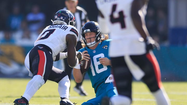 Jacksonville Jaguars quarterback Trevor Lawrence (16) slides for a down as Houston Texans linebacker Azeez Al-Shaair (0) makes a late hit during the second quarter of an NFL football matchup Sunday, Dec. 1, 2024 at EverBank Stadium in Jacksonville, Fla. [Corey Perrine/Florida Times-Union]