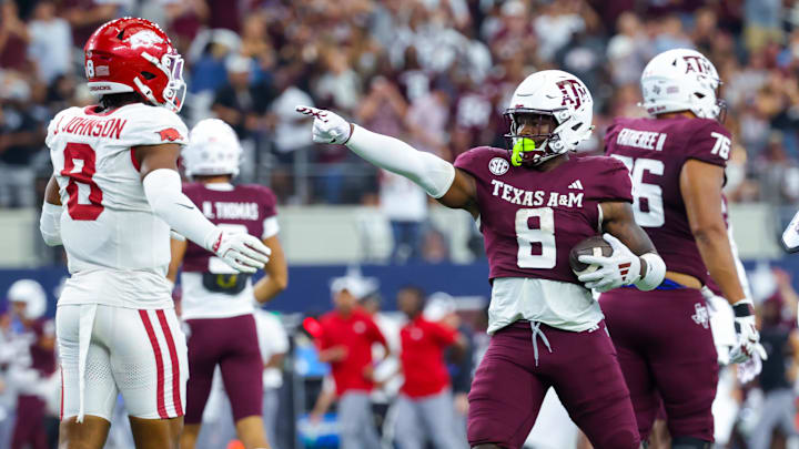 Sep 28, 2024; Arlington, Texas, USA; Texas A&M Aggies running back Le'Veon Moss (8) reacts in front of Arkansas Razorbacks defensive back Jayden Johnson (8) during the second half at AT&T Stadium.