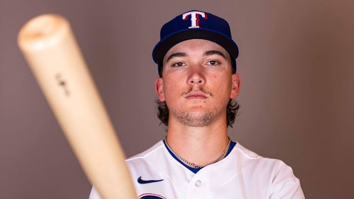 Texas Rangers infielder Cameron Cauley holds a baseball bat while posing for a photo.