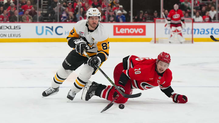 Mar 18, 2026; Raleigh, North Carolina, USA;  Carolina Hurricanes center Sebastian Aho (20) and Pittsburgh Penguins center Sidney Crosby (87) battle over the puck during the third period at Lenovo Center. Mandatory Credit: James Guillory-Imagn Images