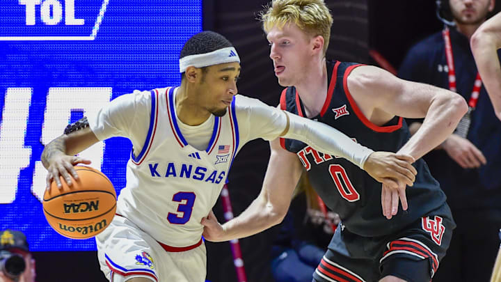 Feb 15, 2025; Salt Lake City, Utah, USA; Utah Utes guard Hunter Erickson (0) defends Kansas Jayhawks guard Dajuan Harris Jr. (3) during the second half at the Jon M. Huntsman Center. Mandatory Credit: Christopher Creveling-Imagn Images
