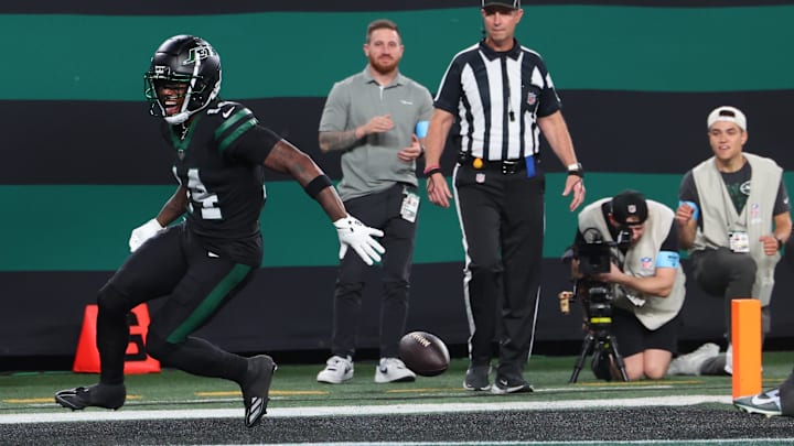 Oct 31, 2024; East Rutherford, New Jersey, USA; New York Jets wide receiver Malachi Corley (14) drops the ball prior to crossing the goal line against the Houston Texans during the first half at MetLife Stadium. Mandatory Credit: Ed Mulholland-Imagn Images