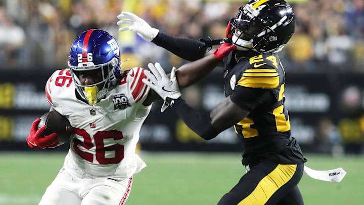 Oct 28, 2024; Pittsburgh, Pennsylvania, USA; New York Giants running back Devin Singletary (26) carries the ball against Pittsburgh Steelers cornerback Joey Porter Jr. (24) during the second quarter at Acrisure Stadium. Mandatory Credit: Charles LeClaire-Imagn Images