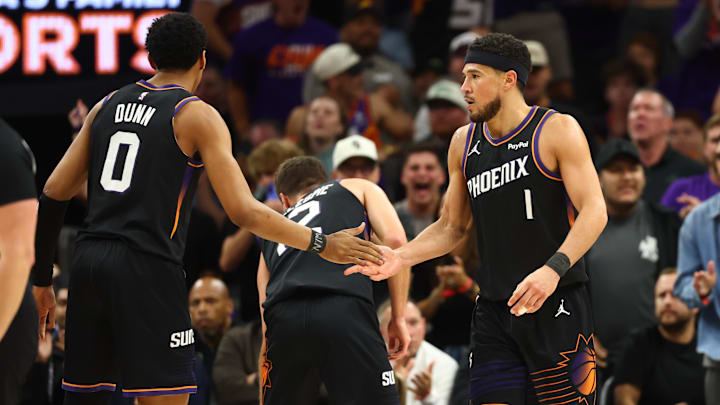 Apr 14, 2026; Phoenix, Arizona, USA; Phoenix Suns guard Devin Booker (1) celebrates with Ryan Dunn (0) against the Portland Trail Blazers in the second half during the play-in rounds of the 2026 NBA Playoffs at Mortgage Matchup Center. Mandatory Credit: Mark J. Rebilas-Imagn Images