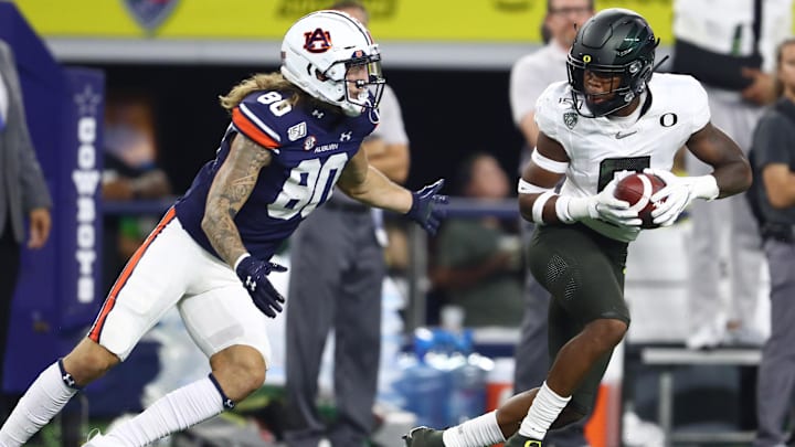 Aug 31, 2019; Arlington, TX, USA; Oregon Ducks safety Jevon Holland (8) intercepts the ball in the second quarter against Auburn Tigers receiver Sal Cannella (80) at AT&T Stadium. Mandatory Credit: Matthew Emmons-Imagn Images