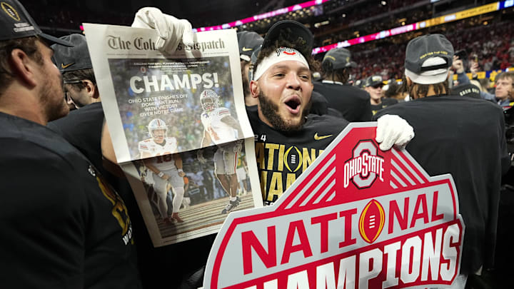 Ohio State Buckeyes wide receiver Brandon Inniss (11) celebrates with a commemorative copy of The Columbus Dispatch following the 34-23 win over the Notre Dame Fighting Irish to win the College Football Playoff National Championship at Mercedes-Benz Stadium in Atlanta on Jan. 22, 2025.