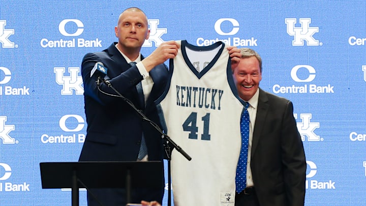 Former Kentucky basketball player and new Kentucky head coach Mark Pope, left, called athletic director Mitch Barnhart back to the stage so he could have a portrait with his actual game jersey as opposed to the random jersey Barnhart chose during his announcement at Rupp Arena in Lexington Ky. on April 14, 2024.