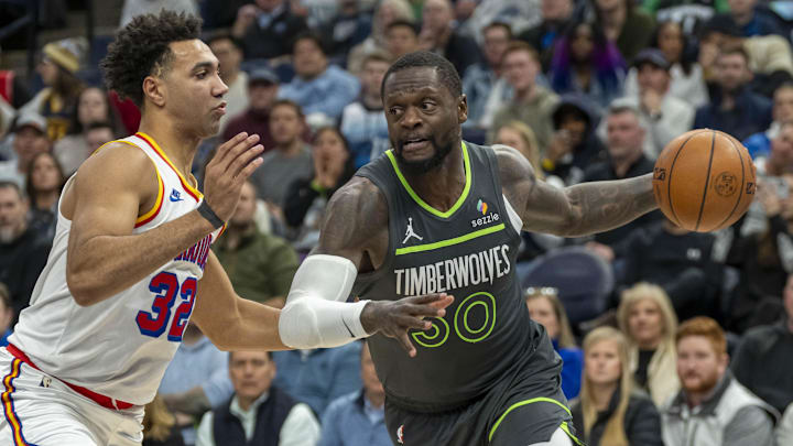 Jan 15, 2025; Minneapolis, Minnesota, USA; Minnesota Timberwolves forward Julius Randle (30) dribbles the ball  past Golden State Warriors forward Trayce Jackson-Davis (32) in the first half at Target Center.