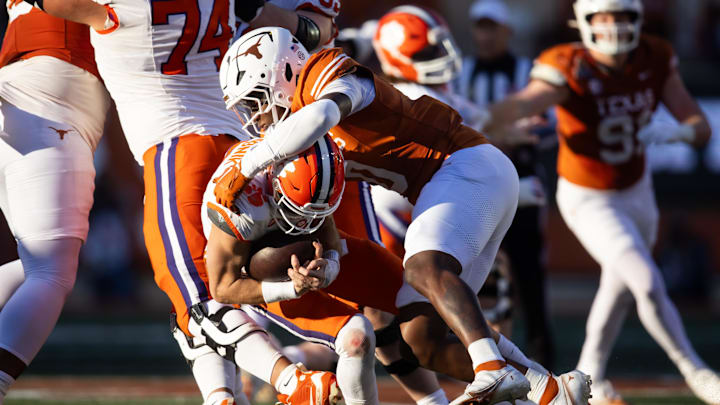 Dec 21, 2024; Austin, Texas, USA; Texas Longhorns linebacker Anthony Hill Jr. (0) tackles Clemson Tigers quarterback Cade Klubnik (2) during the CFP National playoff first round at Darrell K Royal-Texas Memorial Stadium. Mandatory Credit: Mark J. Rebilas-Imagn Images