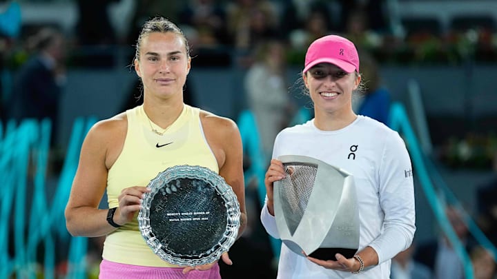 Aryna Sabalebka and Iga Swiatek hold trophies at the 2024 Mutua Madrid Open.