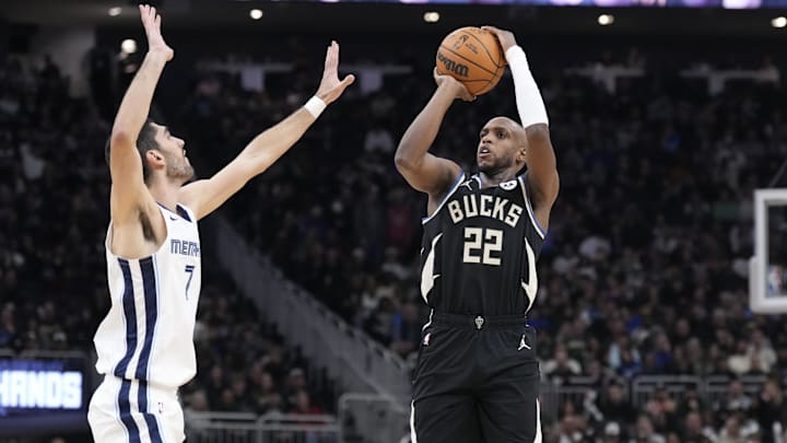 Feb 2, 2025; Milwaukee, Wisconsin, USA; Milwaukee Bucks forward Khris Middleton (22) puts up a shot against Memphis Grizzlies forward Santi Aldama (7) in the first half at Fiserv Forum. Mandatory Credit: Michael McLoone-Imagn Images