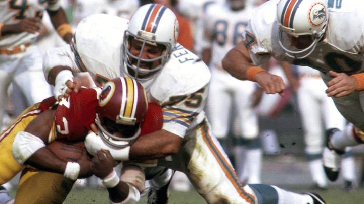 Miami Dolphins defensive tackle Manny Fernandez (75) tackles Washington Redskins running back Larry Brown (43) in Super Bowl VII at the Los Angeles Coliseum. The Dolphins defeated the Redskins 14-7 completing a 17-0 undefeated season. Miami Dolphins defensive tackle Manny Fernandez (75) tackles Washington Redskins running back Larry Brown (43) in Super Bowl VII at the Los Angeles Coliseum. The Dolphins defeated the Redskins 14-7 completing a 17-0 undefeated season.