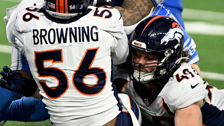 Dec 16, 2023; Detroit, Michigan, USA; Detroit Lions running back David Montgomery (5) is tackled by Denver Broncos linebacker Baron Browning (56) and linebacker Alex Singleton (49) in the second quarter at Ford Field. Mandatory Credit: Lon Horwedel-Imagn Images